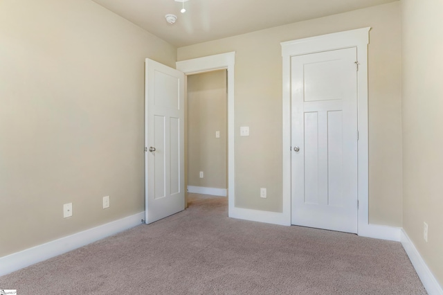 unfurnished bedroom featuring light carpet