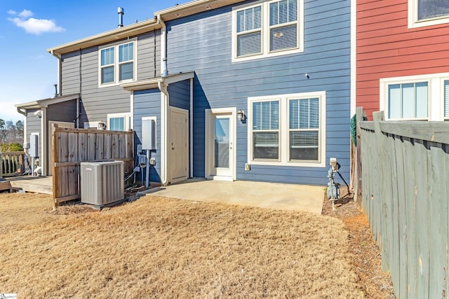 rear view of property with central AC, a patio area, and a lawn