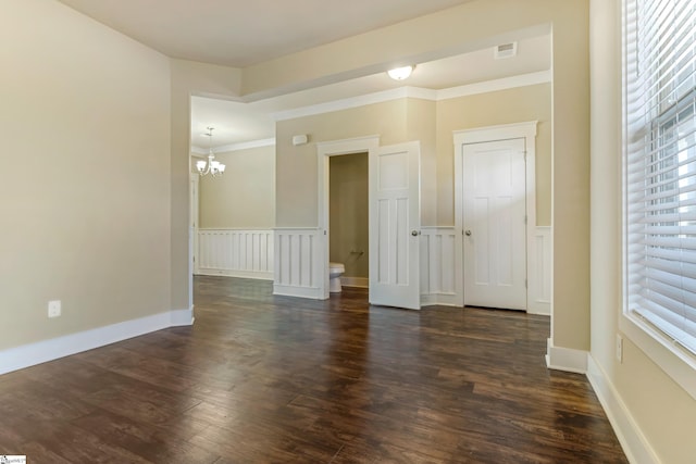 unfurnished room with dark hardwood / wood-style flooring, crown molding, and a chandelier