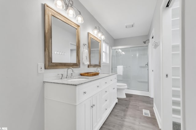 bathroom featuring walk in shower, vanity, and toilet