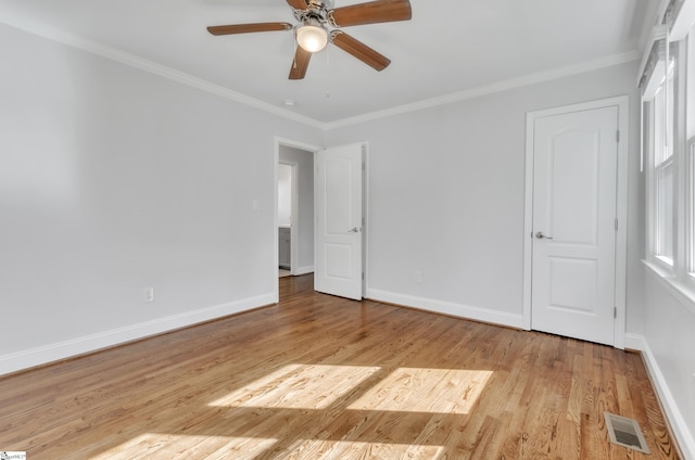 empty room with crown molding, ceiling fan, and light wood-type flooring