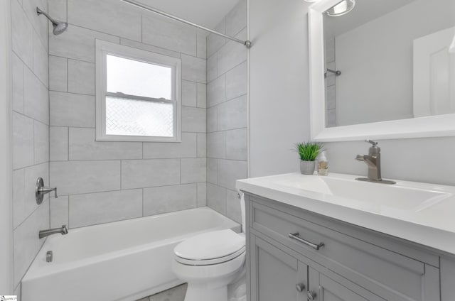 full bathroom featuring vanity, tiled shower / bath combo, and toilet