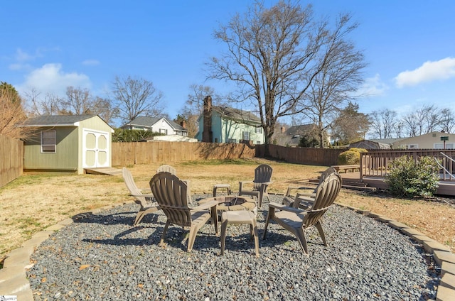 view of yard with a shed, a wooden deck, and an outdoor fire pit