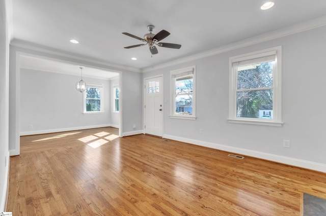 interior space featuring ornamental molding, ceiling fan with notable chandelier, and light wood-type flooring