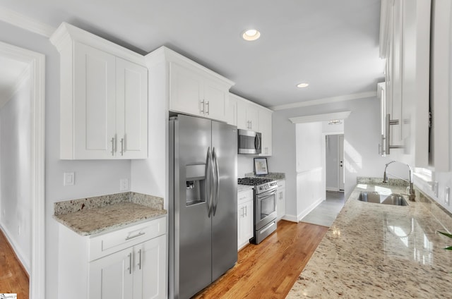 kitchen with white cabinetry, sink, stainless steel appliances, and light stone countertops