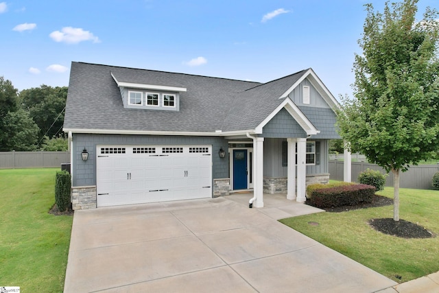 view of front of house with stone siding, a shingled roof, and a front yard