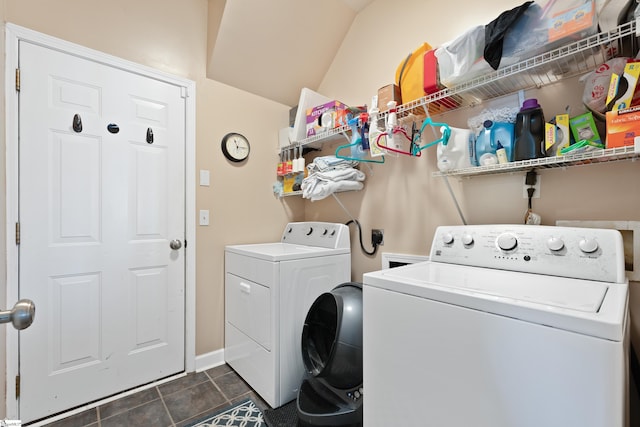 laundry room with washing machine and dryer and dark tile patterned floors