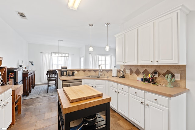 kitchen with white cabinetry, sink, and decorative light fixtures