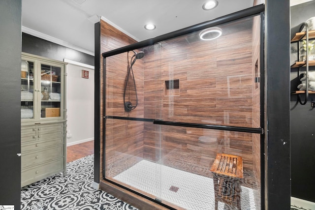 bathroom with crown molding and a shower with door