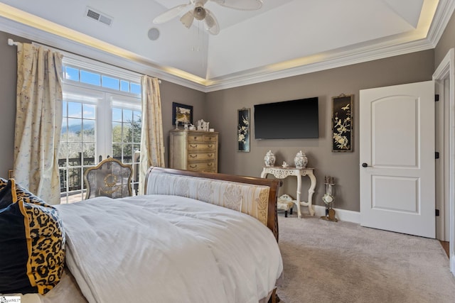 bedroom featuring vaulted ceiling, ceiling fan, a tray ceiling, crown molding, and light carpet