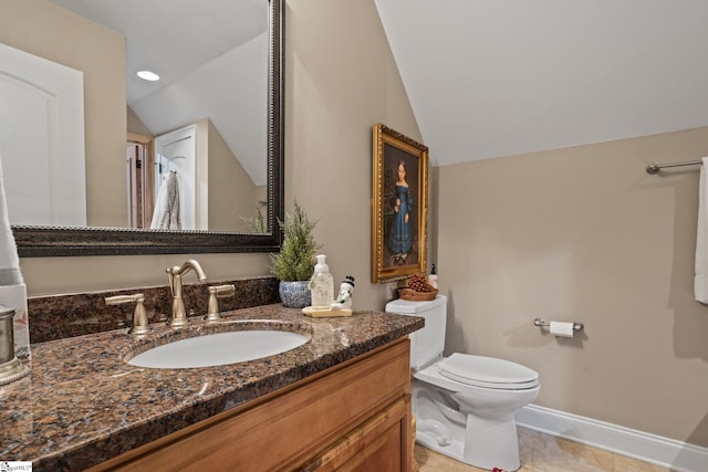 bathroom featuring vanity, toilet, and vaulted ceiling