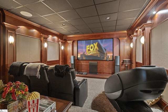 cinema room with ornate columns, crown molding, carpet flooring, and a paneled ceiling