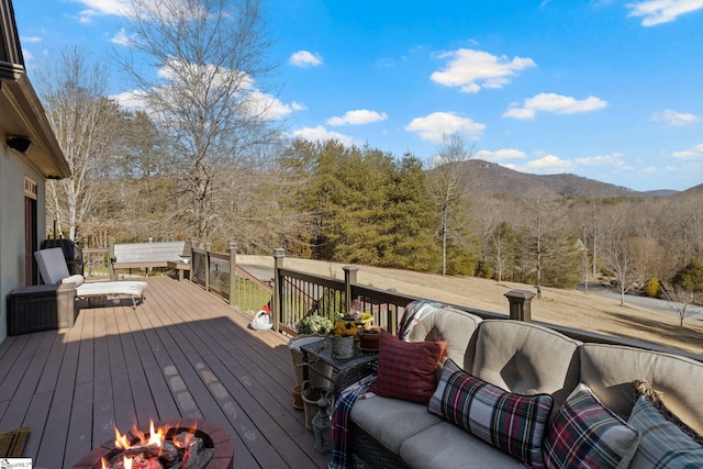 deck with a mountain view and an outdoor living space with a fire pit