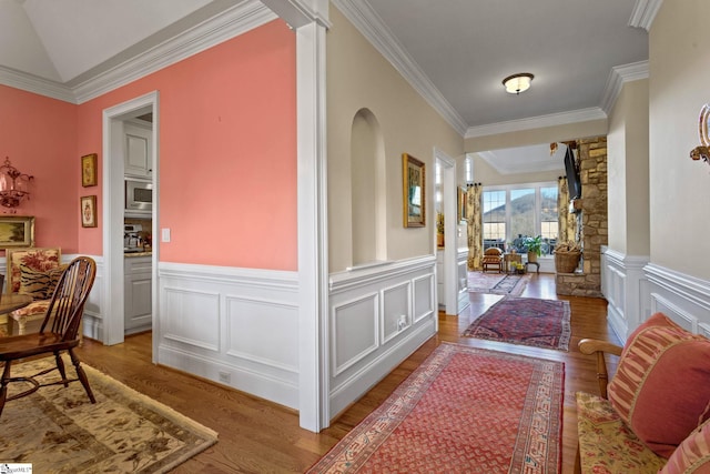 corridor featuring crown molding, decorative columns, and light hardwood / wood-style flooring