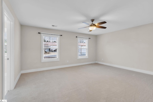 carpeted spare room featuring ceiling fan