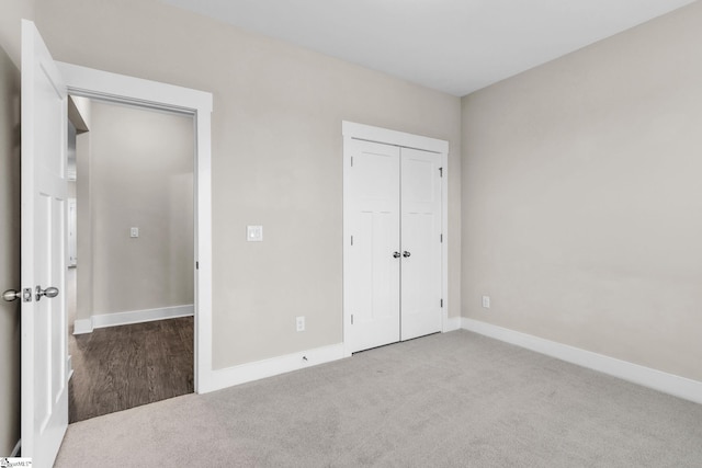 unfurnished bedroom featuring light colored carpet and a closet