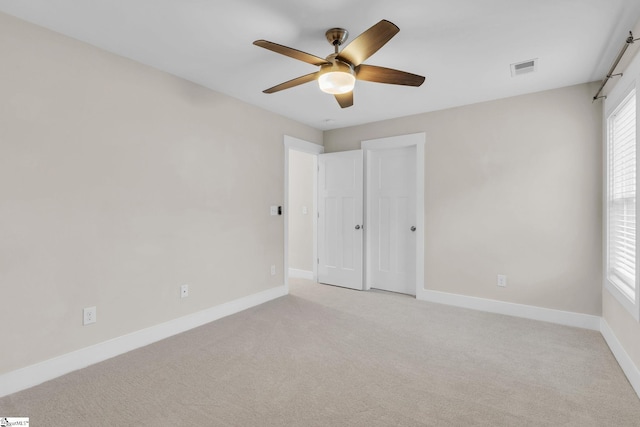 unfurnished room with light colored carpet and ceiling fan