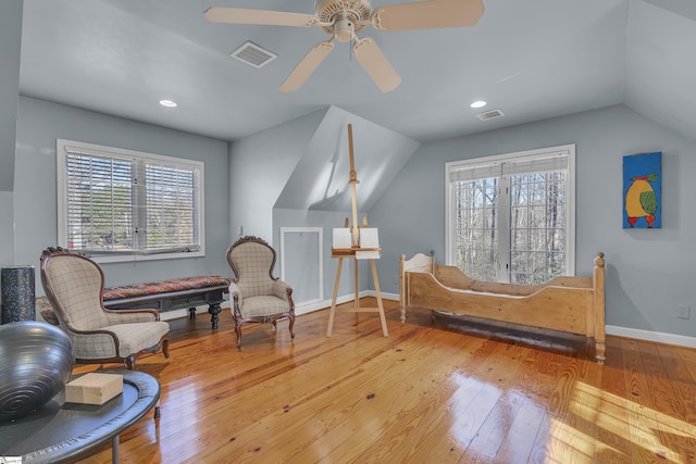 living area with ceiling fan, lofted ceiling, and wood-type flooring