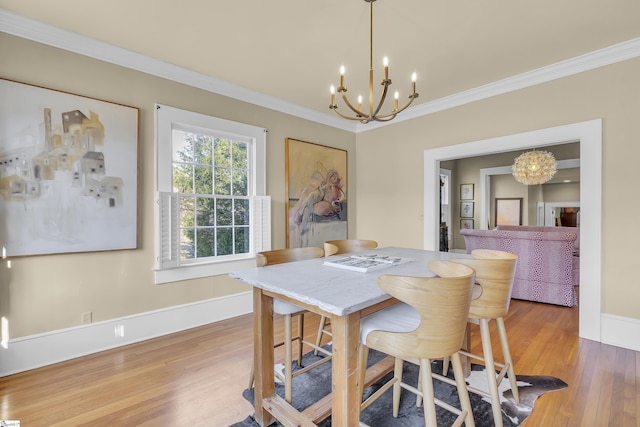 dining space with hardwood / wood-style flooring, crown molding, and an inviting chandelier