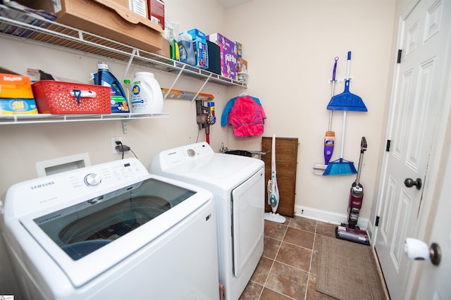 clothes washing area featuring dark tile patterned floors and washing machine and dryer