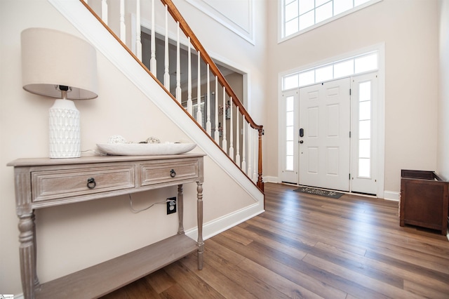 entryway featuring a towering ceiling and dark hardwood / wood-style flooring