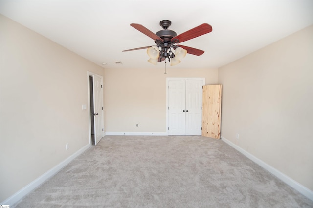 unfurnished bedroom with ceiling fan, light colored carpet, and a closet