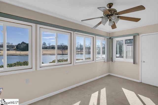 interior space featuring a water view, ceiling fan, and plenty of natural light