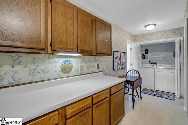 kitchen with a textured ceiling and independent washer and dryer