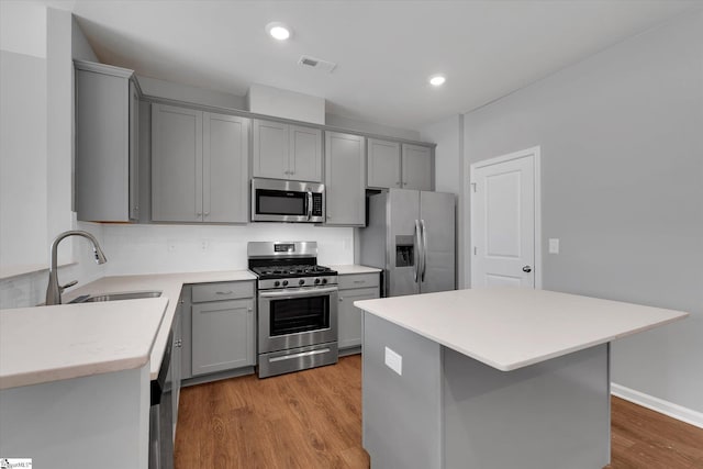 kitchen featuring stainless steel appliances, sink, and gray cabinetry