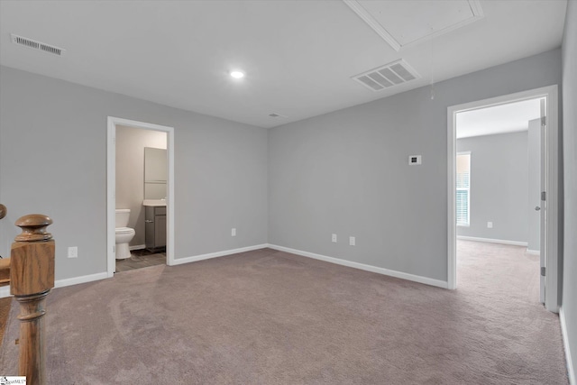 unfurnished bedroom featuring light carpet and connected bathroom