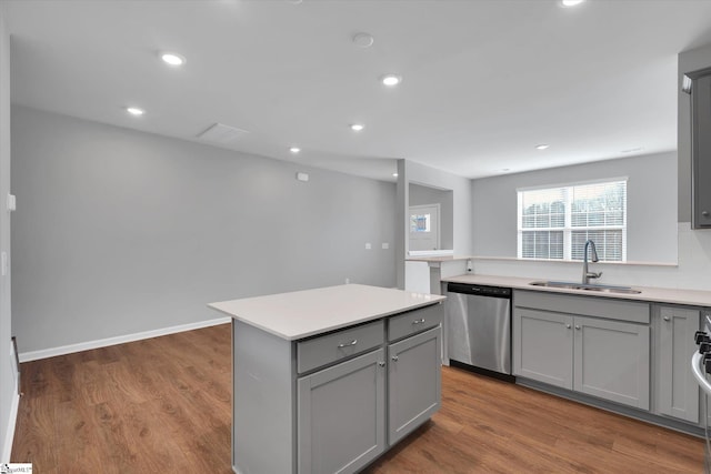 kitchen featuring sink, dark wood-type flooring, gray cabinets, a center island, and stainless steel dishwasher