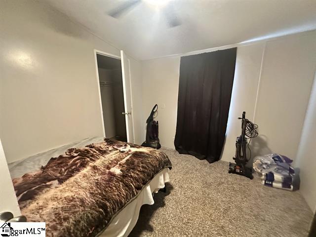 bedroom with lofted ceiling, ceiling fan, and carpet flooring