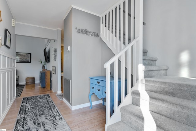 entrance foyer with crown molding and wood-type flooring