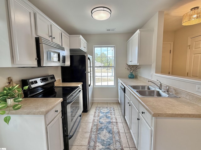 kitchen featuring white cabinetry, appliances with stainless steel finishes, sink, and light tile patterned floors