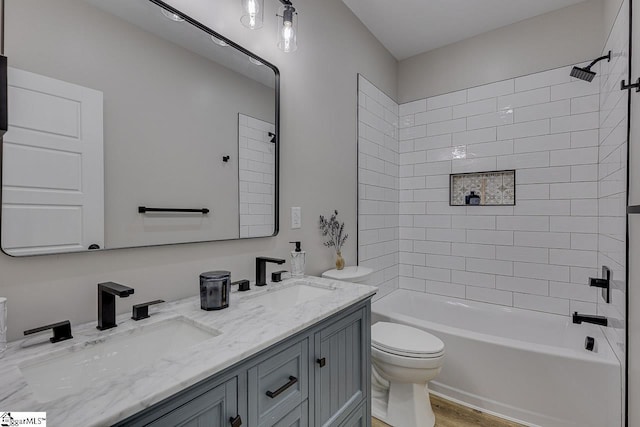 full bathroom with vanity, hardwood / wood-style floors, toilet, and tiled shower / bath