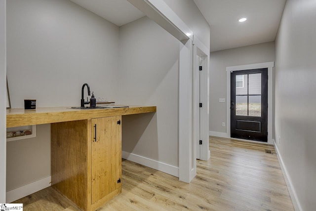 bar with sink and light hardwood / wood-style flooring