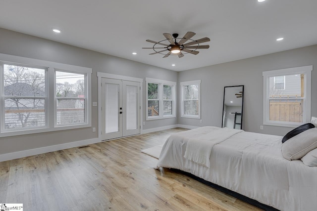 bedroom featuring multiple windows, ceiling fan, and light hardwood / wood-style flooring