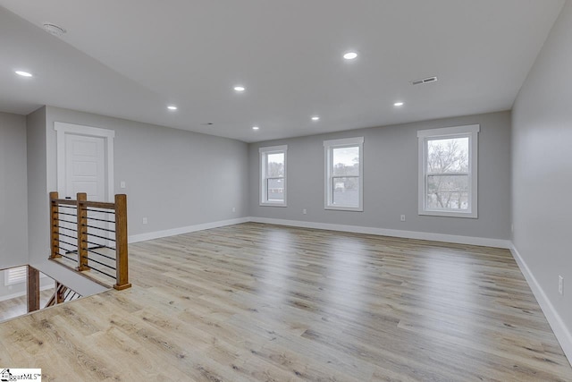 unfurnished room with a healthy amount of sunlight and light hardwood / wood-style flooring