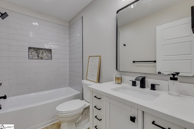 full bathroom featuring vanity, tiled shower / bath combo, and toilet