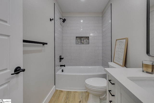 full bathroom featuring tiled shower / bath combo, vanity, hardwood / wood-style floors, and toilet