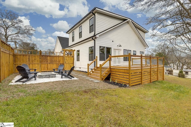 back of property featuring a patio, a deck, a fire pit, and a lawn