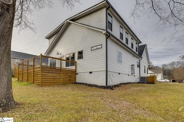 back of property with central AC unit, a yard, and a deck