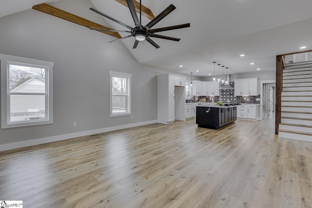 unfurnished living room featuring light hardwood / wood-style flooring, high vaulted ceiling, and ceiling fan