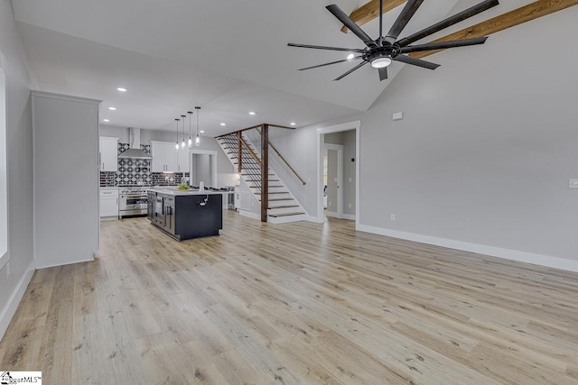 unfurnished living room featuring vaulted ceiling, light hardwood / wood-style floors, and ceiling fan