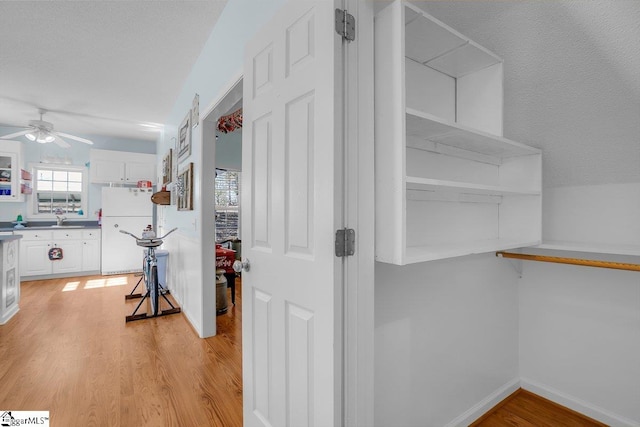 interior space featuring sink, light hardwood / wood-style floors, and a textured ceiling