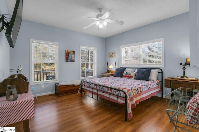 bedroom featuring ceiling fan, hardwood / wood-style floors, and a textured ceiling