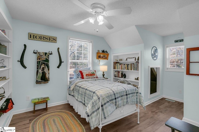 bedroom featuring multiple windows, wood-type flooring, and a textured ceiling