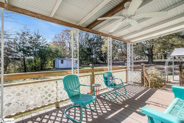 wooden deck featuring a shed and ceiling fan