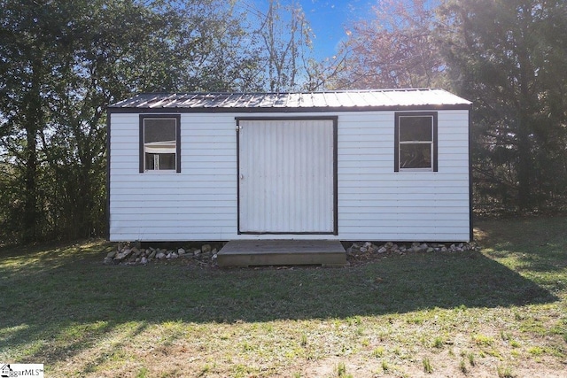 view of outbuilding with a yard