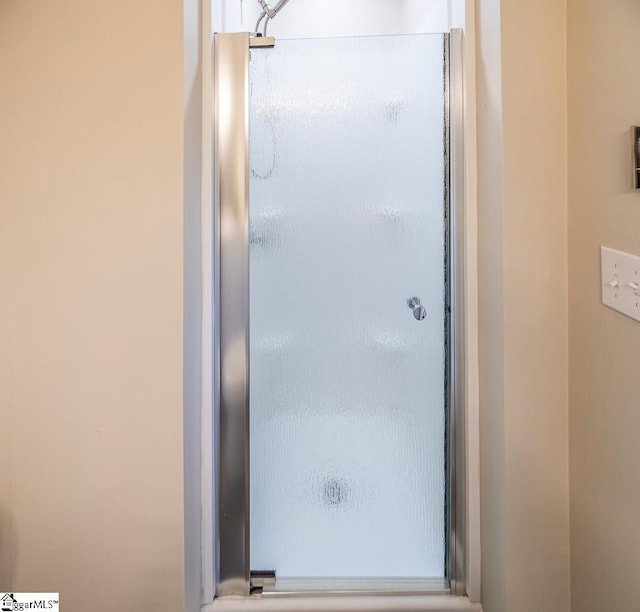 bathroom featuring a shower with door